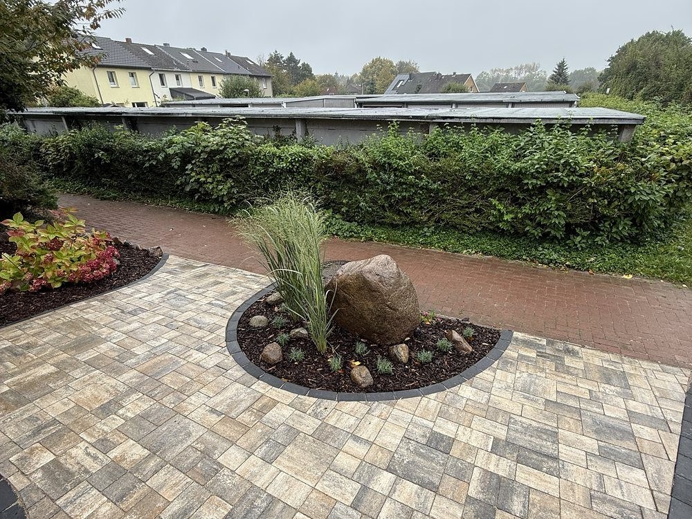 Hoffläche in Klinkerpflaster mit rundem Beet und Findling