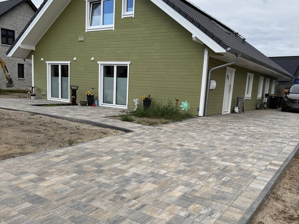 Gepflasterte Einfahrt mit Zufahrt zur Garage an einem Wohnhaus