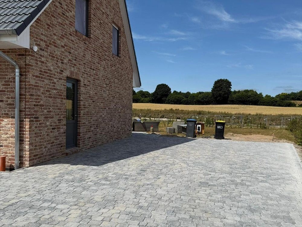 Stellfläche in Betonpflaster neben einem Klinkerhaus
