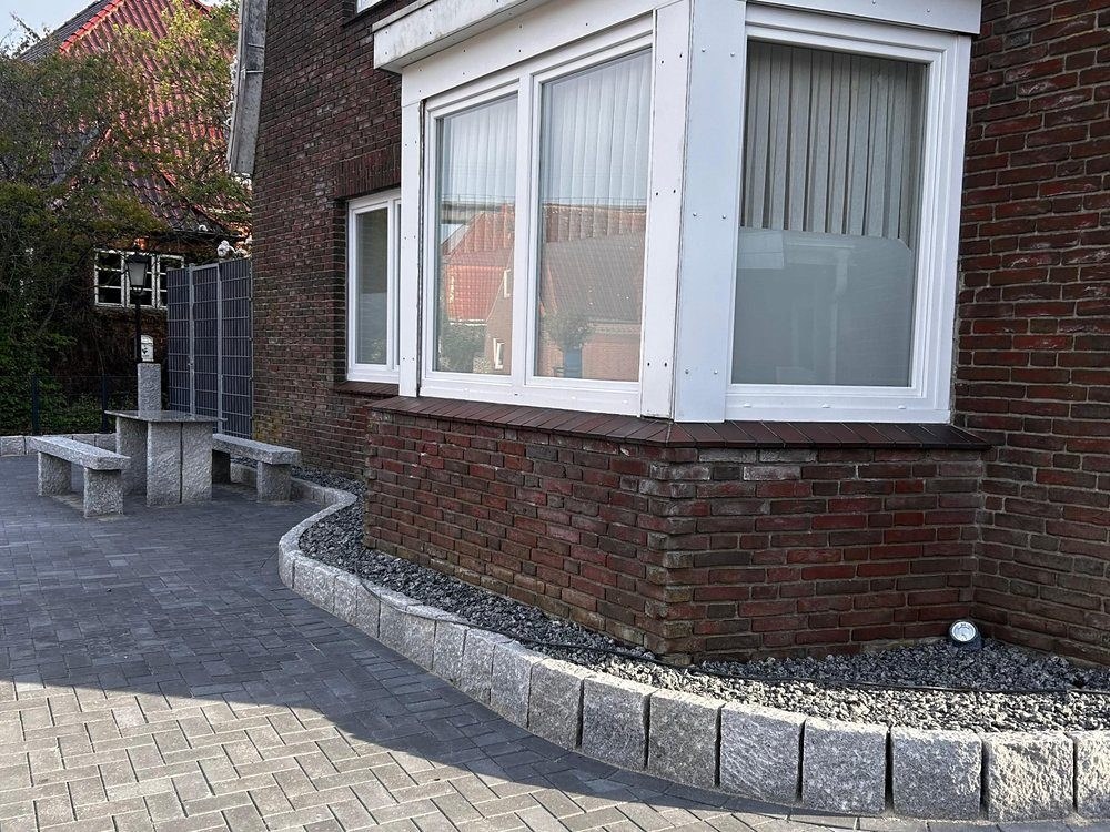 Hausecke mit gepflasterter Randeinfassung und Kiesstreifen